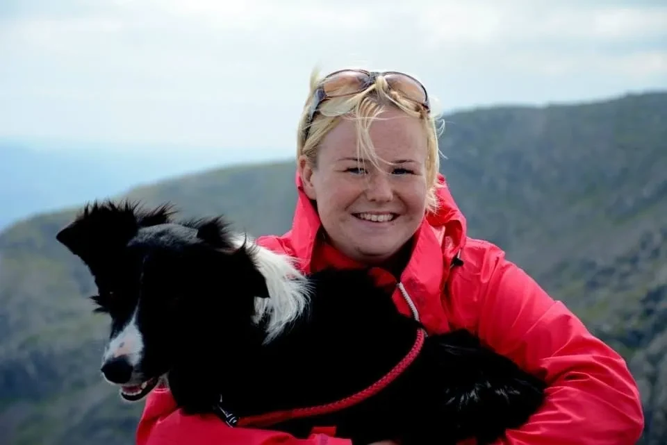 Trainer outdoors with a black and white dog